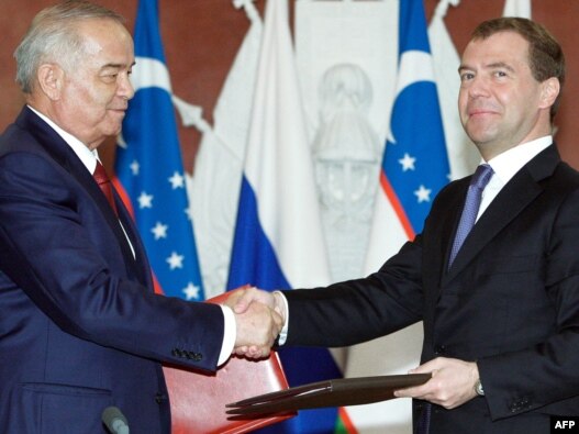 Russian President Dmitry Medvedev (right) exchanges documents with Uzbek counterpart Islam Karimov in Moscow.