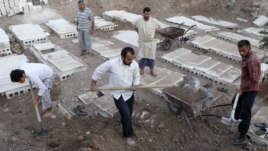 Syria -- Volunteers bury bodies found in some houses after a recent Syrian Air Force air strike in Azaz, some 47 km north of Aleppo, 20Aug2012