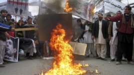 Afghans protesters burn posters of Iran's leaders during a demonstration in Jalalabad Province.