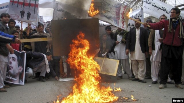 Afghans protesters burn posters of Iran's leaders during a demonstration in Jalalabad Province.