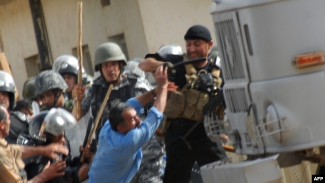 Iraqi police clash with exiled Iranian dissidents inside Camp Ashraf in 2009.