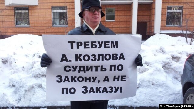 A man in front of a Moscow court protests the prosecution of entrepreneur Aleksei Kozlov.