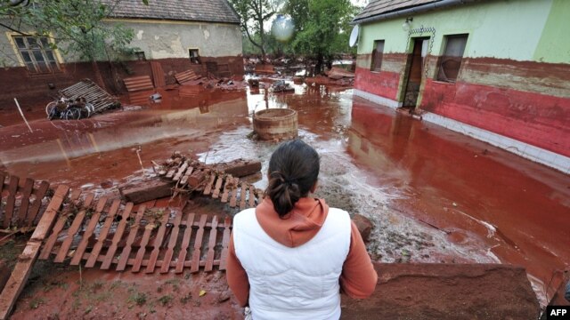 A woman looks at the damage in Devecser, Hungary, on October 5.