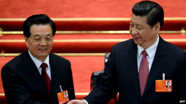Newly elected President Xi Jinping (right) shakes hands with former President Hu Jintao after Xi was also elected as chairman of the Central Military Commission during the 12th National People's Congress  in Beijing on March 14.