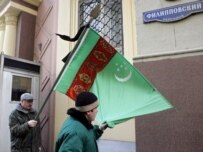 Demonstrators outside the Turkmen Embassy in Moscow hold a Turkmen flag with a black ribbon today (epa)