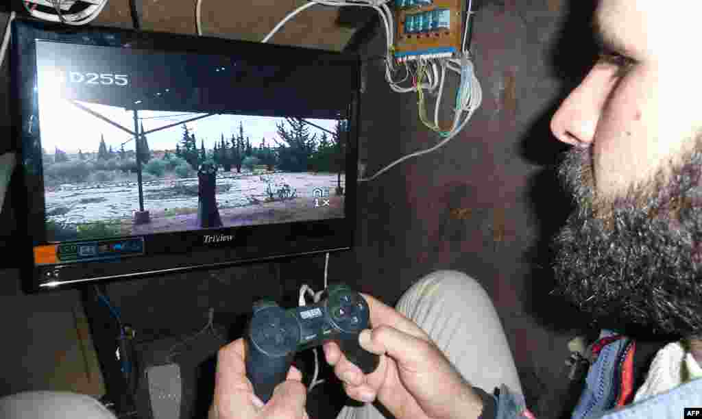 A Syrian rebel uses a control stick to activate the machine gun of the Sham II, the homemade armored vehicle made by the rebels' Al-Ansar Brigade, in Bishqatin, 4 kilometers west of Aleppo.