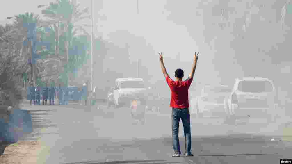 An antigovernment protester gestures as he stands in tear gas fired by riot police near the village of Diraz, west of Manama, Bahrain. (Reuters)