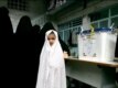 A girl waits while women vote at a Tehran polling station.