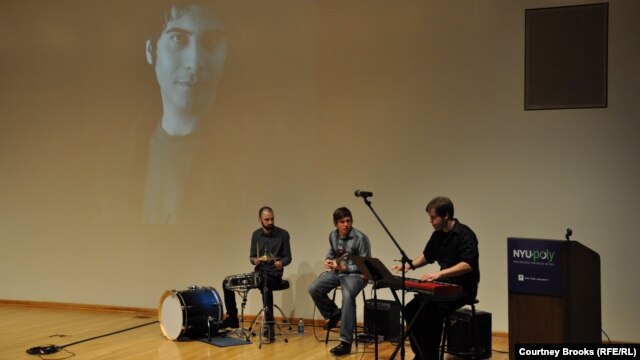 Brooklyn-based band Less Magnetic plays the music of imprisoned Iranian singer Arya Aramnejad (pictured on the screen) during a concert in New York to raise awareness of his plight.