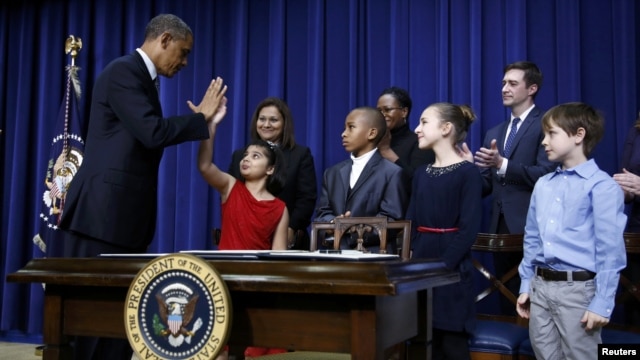 U.S. President Barack Obama high-fives 8-year-old Hinna Zejah after unveiling a series of gun-control proposals during an event at the White House on January 16.