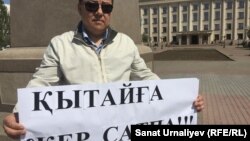 Гражданский активист Исатай Утепов во время одиночного пикета на центральной площади Уральска. 24 апреля 2016 года.