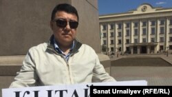 Гражданский активист Исатай Утепов во время одиночной акции протеста на центральной площади Уральска". 24 апреля 2016 года.