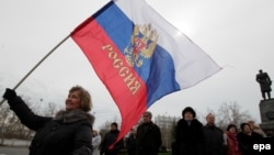 A woman holds a Russian flag on a central square in Sevastopol, the Crimean capital, on March 16.