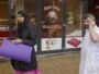 Netherlands -- A butcher talks on his mobile phone as a veiled woman passes a Halal butchers store in Amsterdam, 31Mar2011