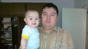 Узбекский беженец Рахим Собиров со своим сыном на руках. Алматинская область, август 2011 года. 