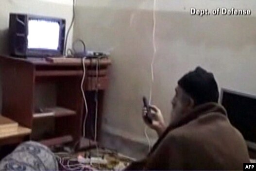  اسامه بن‌لادن در حال دیدن اخبار خود از تلویزیون( عکس از ویدئو  گرفته شده است)