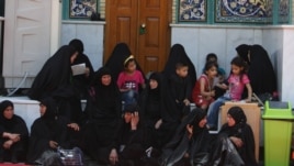 Women and children sit at the shrine of Imam Mussa al-Kadhim in the district of Kadhimiya.