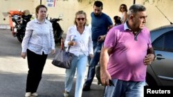 Turkish journalist Nazli Ilicak (center), a well-known commentator and former parliament deputy, is escorted by a police officer and relatives after being detained in Bodrum days after the failed coup in Turkey on July 15.