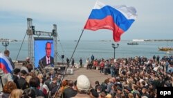 Crimean residents watch a TV broadcast with Russian President Vladimir Putin after the peninsula was annexed by Moscow earlier this year.