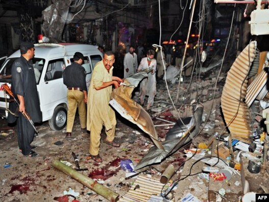 Would-be rescuers and police at the scene of the twin bombings that killed dozens at a crowded market in Peshawar on June 11 and 12