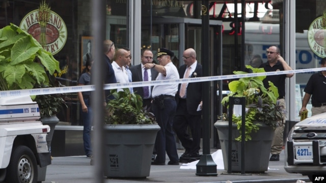 Police stand near the covered body of the suspected shooter on 5th Avenue near the Empire State Building in New York City on August 24.