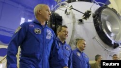 Российские космонавты Алексей Овчинин (третий слева), Олег Скрипочка (второй слева) и астронавт Национального космического агентства США (NASA) Джеффри Уильямс.