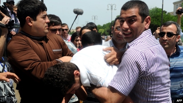 Plainclothes Azerbaijani police officers on May 23 detain the opposition activists who tried to hold a rally near the public television station that is showing the Eurovision broadcasts in Baku.