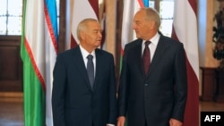 Latvian President Andris Berzins (right) and Uzbek counterpart Islam Karimov pose in front of their national flags as they meet in Riga on October 17.