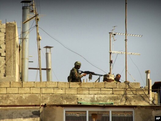 An image provided to AP by a citizen jouralist in May of Syrian soldiers on the roof of a building at an undisclosed location.