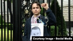 Christian Jereghi demonstrates with a picture of Oleh Sentsov, a filmmaker from Crimea detained in Moscow.