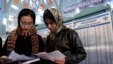 Two Iranian women cast ballots at a polling station in Tehran in Iran