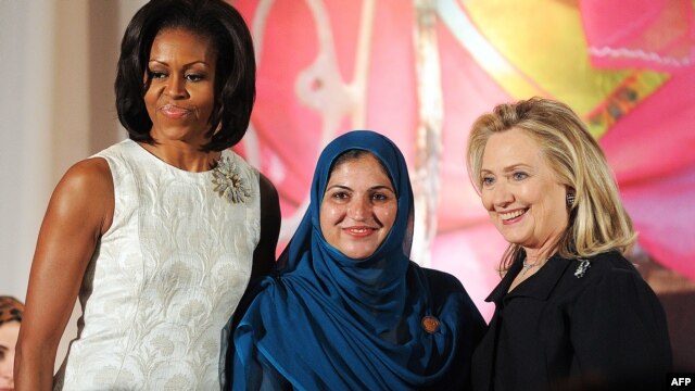 U.S. first lady Michelle Obama (left) and Secretary of State Hillary Clinton (right) pose with Shad Begum of Pakistan as she receives the 2012 International Women of Courage award in Washington.