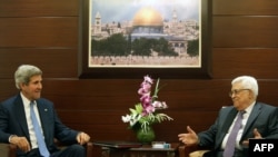 U.S. Secretary of State John Kerry (left) meets with Palestinian Authority President Mahmud Abbas on July 19 at the Mukataa compound in the West Bank city of Ramallah.