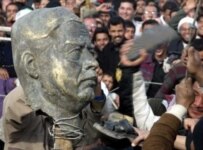 A torn down statue of Saddam Hussein being hit with shoes in Sadr City on December 26, 2003 (epa)