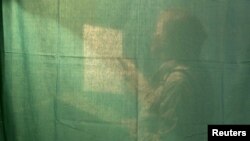 Transparent enough yet? A voter is seen behind the curtain of a voting booth in Minsk during Belarusian parliamentary elections in September that EU foreign policy chief Catherine Ashton called a "missed opportunity" for President Alyaksandr Lukashenka's regime.