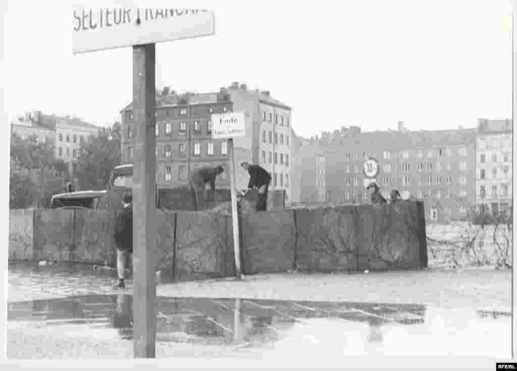 East German police patrol a temporary, prefabricated section of the Berlin Wall. After midnight on August 13, East German troops began erecting what Communist East German leader Walter Ulbricht called an "anti-fascist protection barrier." Two months earlier, on June 15, he had declared: "Nobody intends to build a wall."