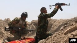 Iraqi soldiers fire toward Islamic State (IS) militants outside Ramadi on May 19. An Iraqi soldier describes how he and his comrades were left isolated in Ramadi.