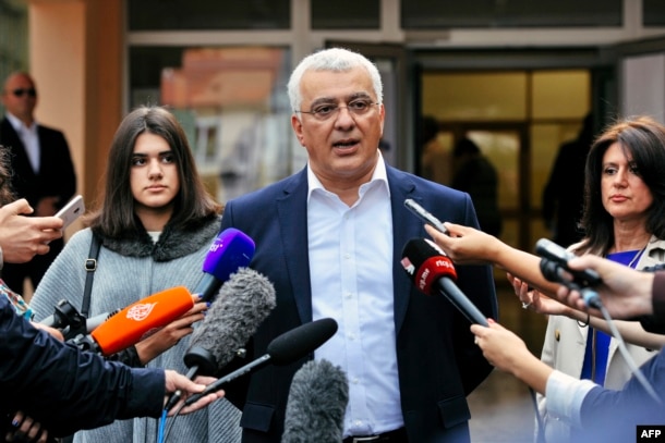 Andrija Mandic, leader of the Democratic Front, speaks to journalists after voting.