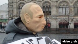 Ресей президенті Владимир Путиннің келбетіндегі маска киген белсенді Қызыл алаң маңында тұр. Мәскеу, 7 сәуір 2016 жыл.