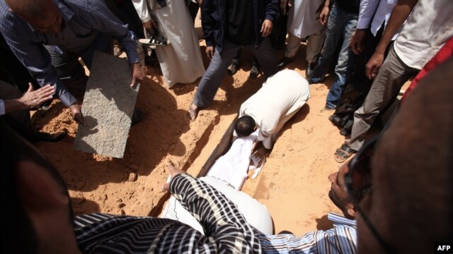 Friends and relatives bury the body of Abdelbaset al-Megrahi during his funeral in Tripoli. 