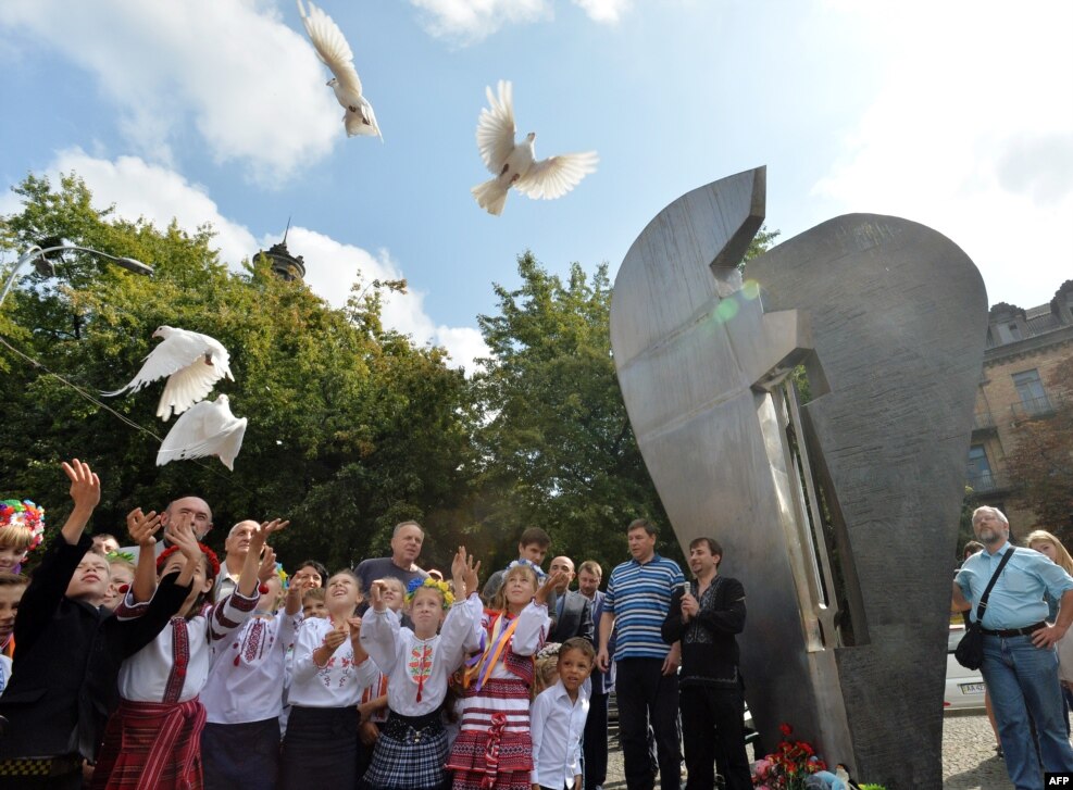 Fëmijët lëshojnë pëllumba të bardhë përpara monumentit kushtuar viktimave të terrorizmit në Kiev të Ukrainës, më 11 shtator 2014. Monumenti, i cili u përurua në vitin 2005, ka të gdhendur mbishkrimin &ldquo;Ti nuk duhet të vrasësh&rdquo;, në 120 gjuhë të botës.