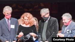 Dr. Elena Bodnar demonstrates her invention, assisted by Nobel laureates Wolfgang Ketterle (left to right), Orhan Pamuk, and Paul Krugman.