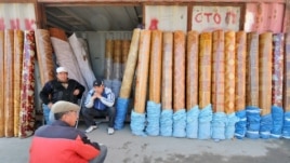 Traders sit outside a converted shipping container at a bazaar in southern Kyrgyzstan.