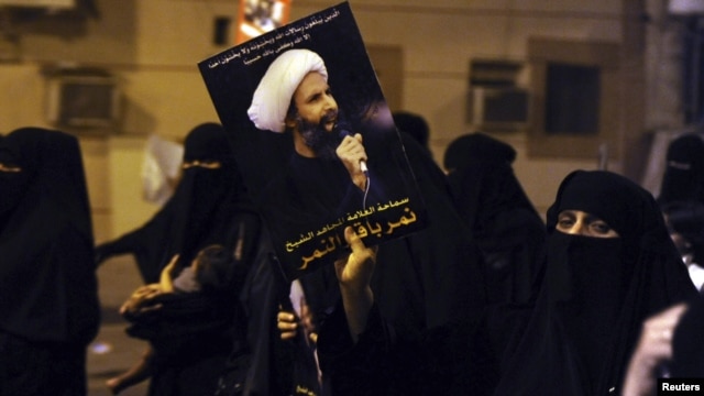 پوستری از شیخ نمر النمر در دستان معترضان شیعه عربستان سعودی