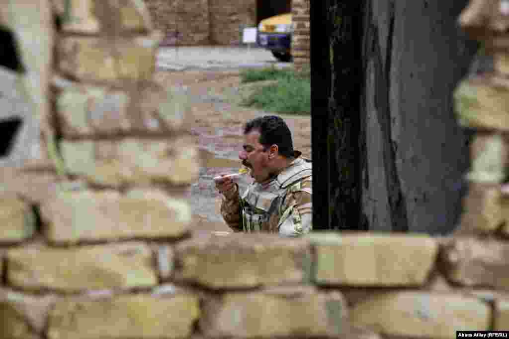 A militiaman takes a lunch break while guarding the Al-Madain, the site of an ancient metropolis spanning the Tigris River south of Baghdad.