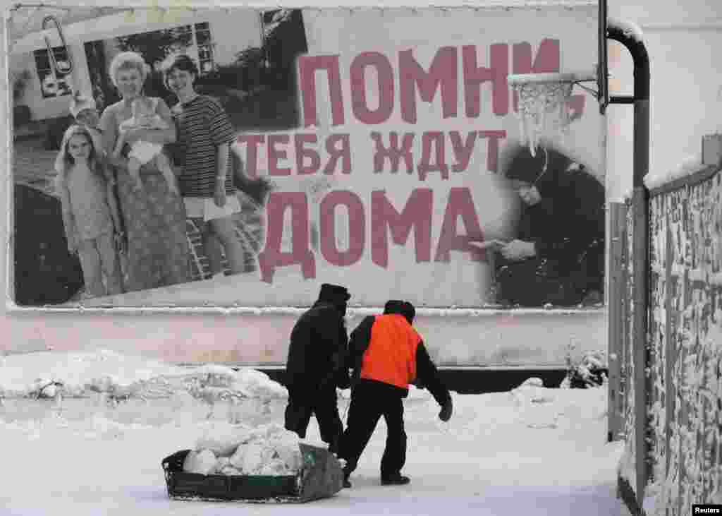 Russian prisoners remove snow as they create snow sculptures for Christmas and New Year's celebrations in an open-air enclosure at a high-security prison in Krasnoyarsk.