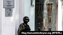 A file photo of a member of the local security forces standing guard outside the offices of the Crimean Tatar's Mejlis in Simferopol. The Tatar community on the Black Sea peninsula have complained of discrimination and harassment since the territory was forcibly annexed by Russia in 2014.