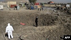 Afghan security personnel inspect the area after a powerful truck bomb targeting a hotel used by foreign contractors exploded on the outskirts of Kabul.