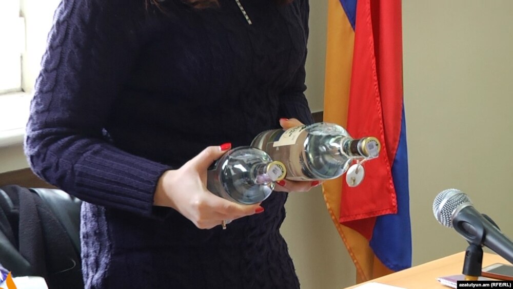 «Վլակտոր Թրեյդինգ Լիմիթեդ» ընկերության ներկայացուցիչը դատարանի դահլիճում ցուցադրում է «Զելյոնայա մետկա» օղու շշերը: