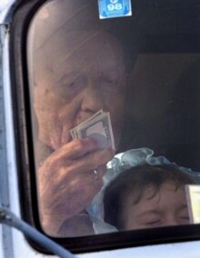 Russia -- Chechnya; elderly Chechen refugee w/ grandchild and U.S. dollars approaches Ingush-Chechen checkpoint Jan2000